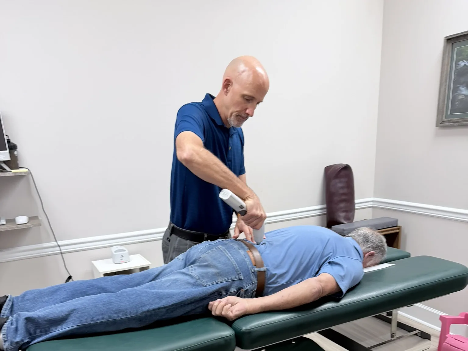 Dr. Jon Scott, chiropractor near Bearden, TN, adjusting a patient with the Activator instrument