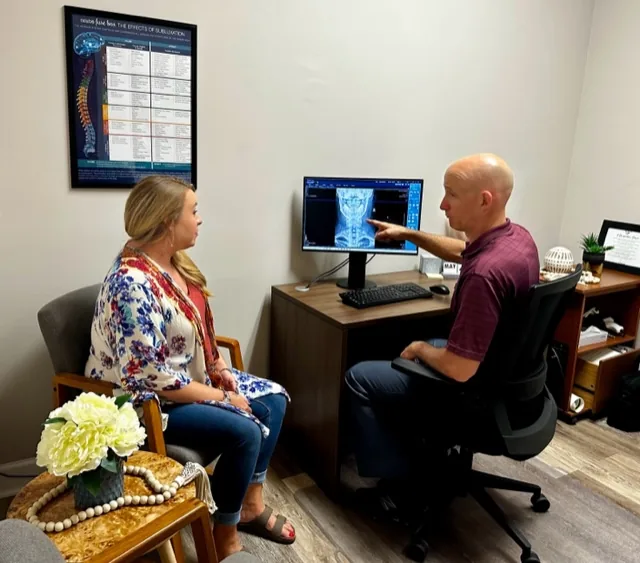Dr. Jon Scott reviewing a cervical X-ray with a patient